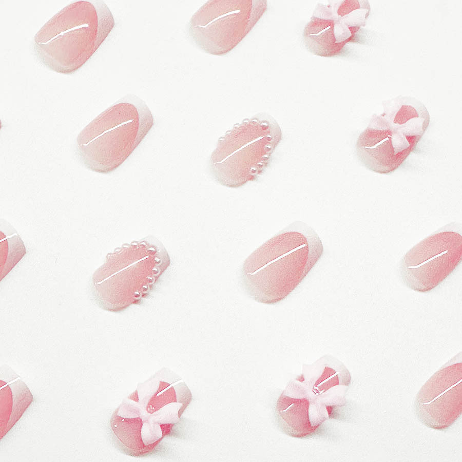 Artificial nails with elegant bows and pearl embellishments Bowlift