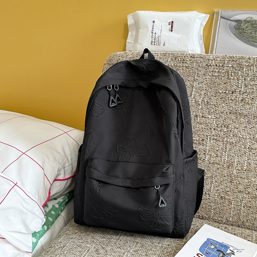 Elegant Textured Backpack with Decorative Charm