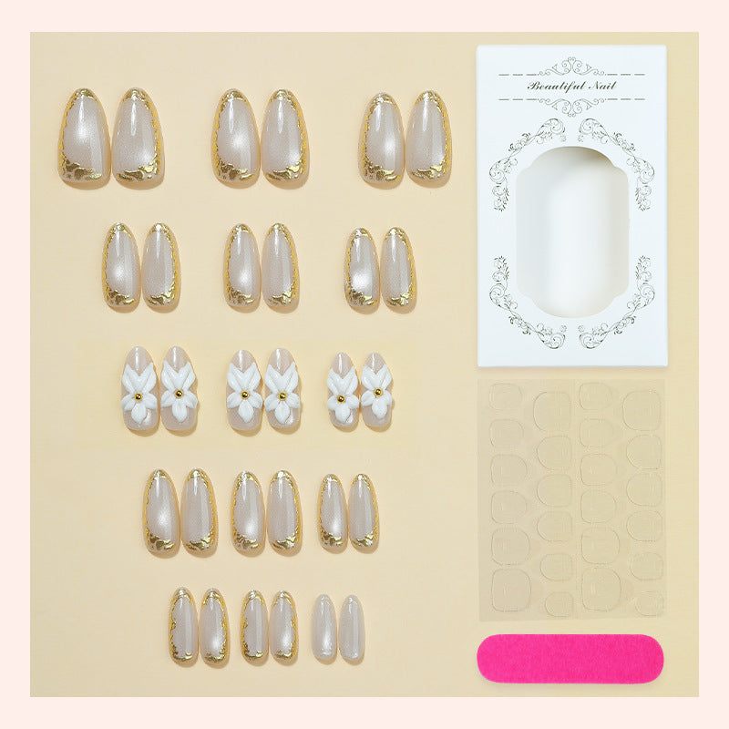 Acrylic nail set with elegant gold embellishments and floral accent Bowlift