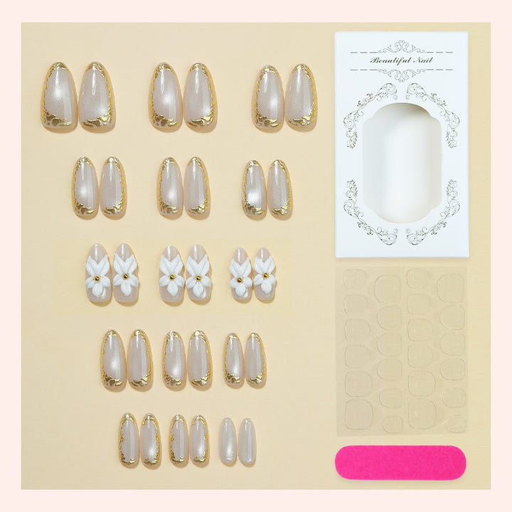 Acrylic nail set with elegant gold embellishments and floral accent Bowlift