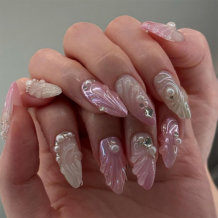 Artificial nail art with elegant swirl design and pearl embellishments Bowlift