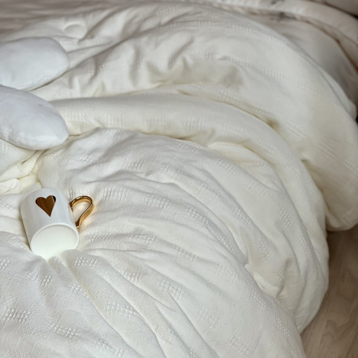 Light quilted comforter with climate-regulating hollow fiber filling and fine textured cover