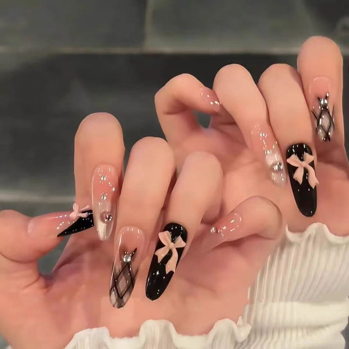 Artificial nails with playful bow and glitter accents Bowlift