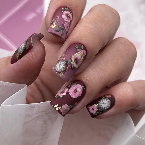 Nail art with floral design and intricate clock motifs Bowlift