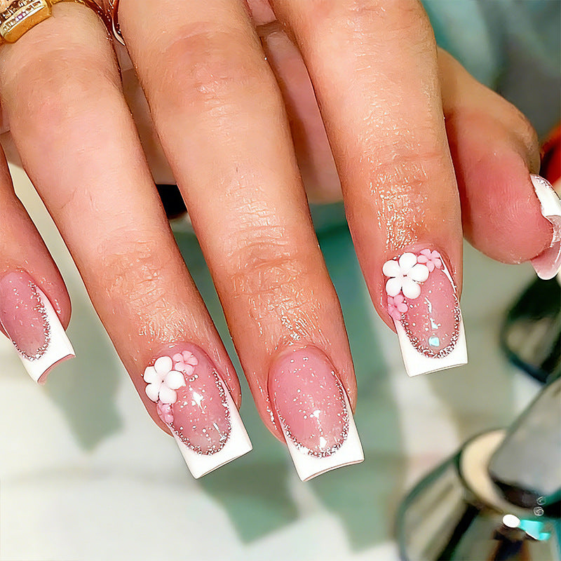 Acrylic nail set with elegant French tip and delicate floral decorations Bowlift