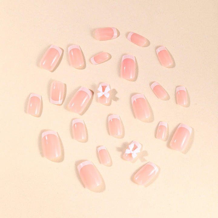 Elegant French Tip Nail Art with Bow Embellishments Bowlift