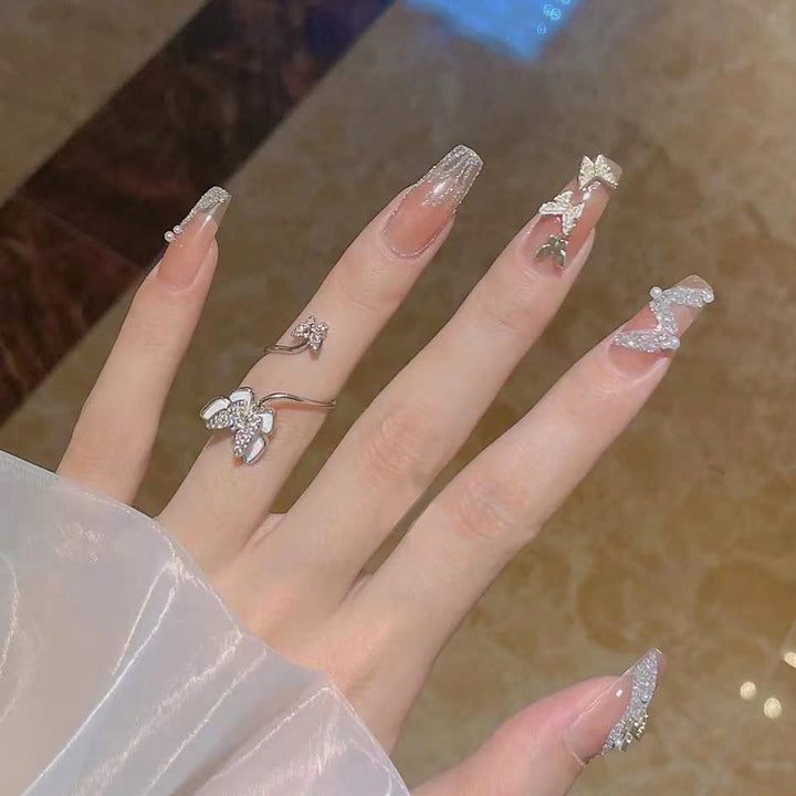 Artificial nails with sparkling rhinestone and bow accents Bowlift