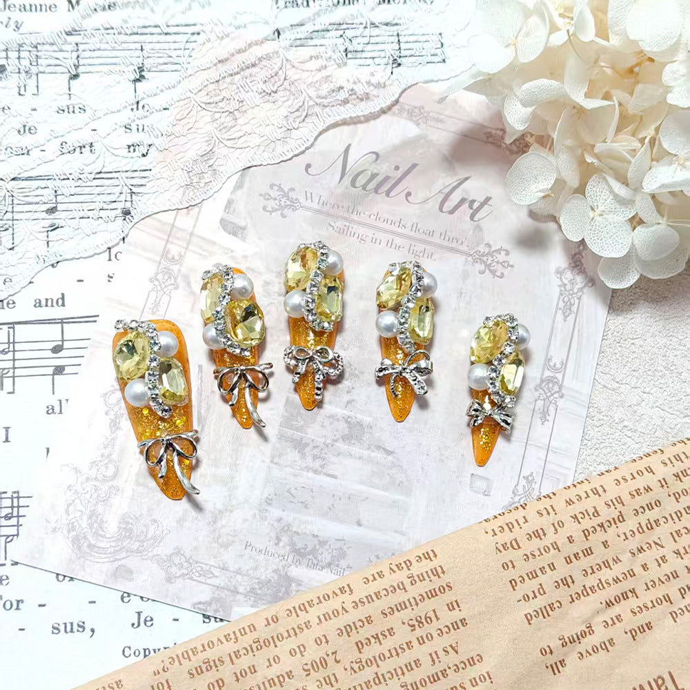Glamorous artificial nails with rhinestones and pearl embellishments Bowlift