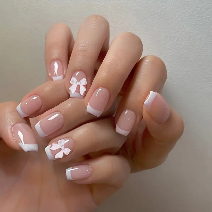 Elegant French Tip Nail Art with Bow Embellishments Bowlift