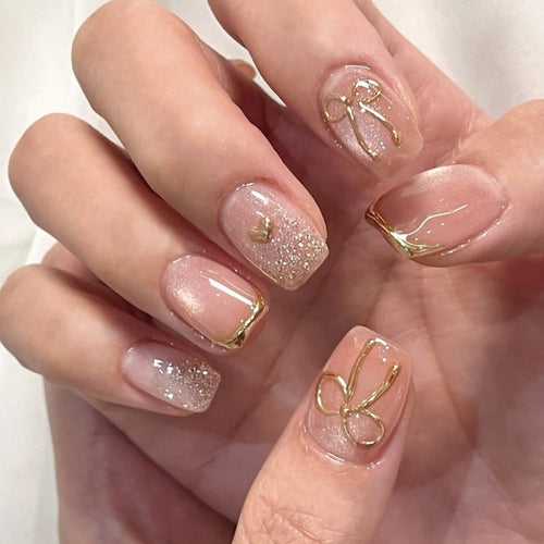 Glamorous acrylic nails with elegant gold design Bowlift