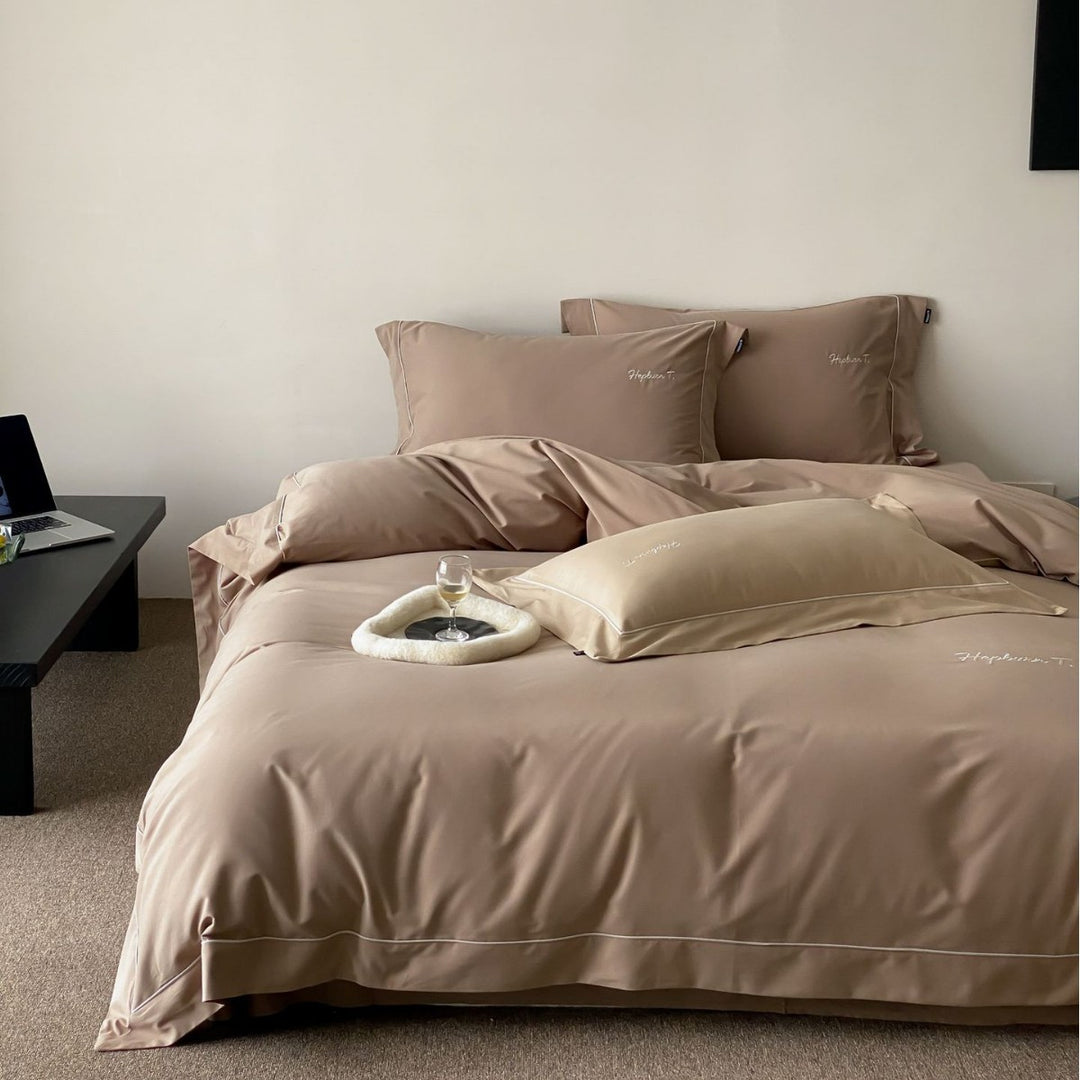 Elegant cotton satin bedding set with fine piped trim and monogram embroidery