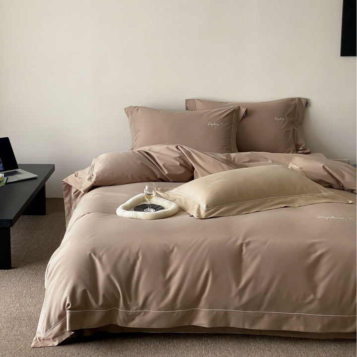 Elegant cotton satin bedding set with fine piped trim and monogram embroidery