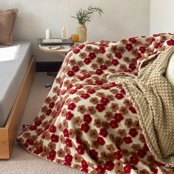 Patterned throw blanket with woven flower appliqués