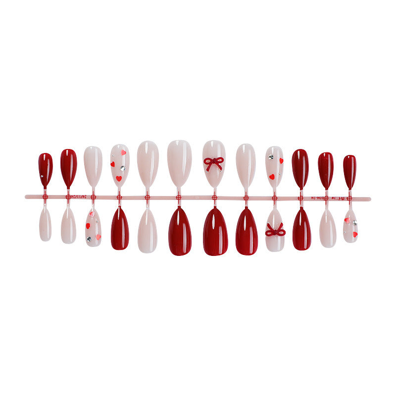 Artificial nail set with festive heart and bow accents Bowlift