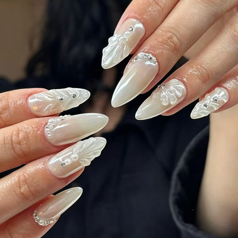 Elegant Stiletto Nail Enhancements with Decorative Pearls Bowlift