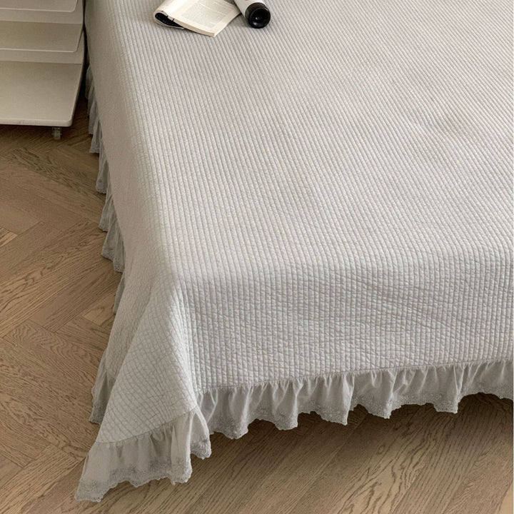 Quilted bedspread with ruffled trim and fine quilted texture