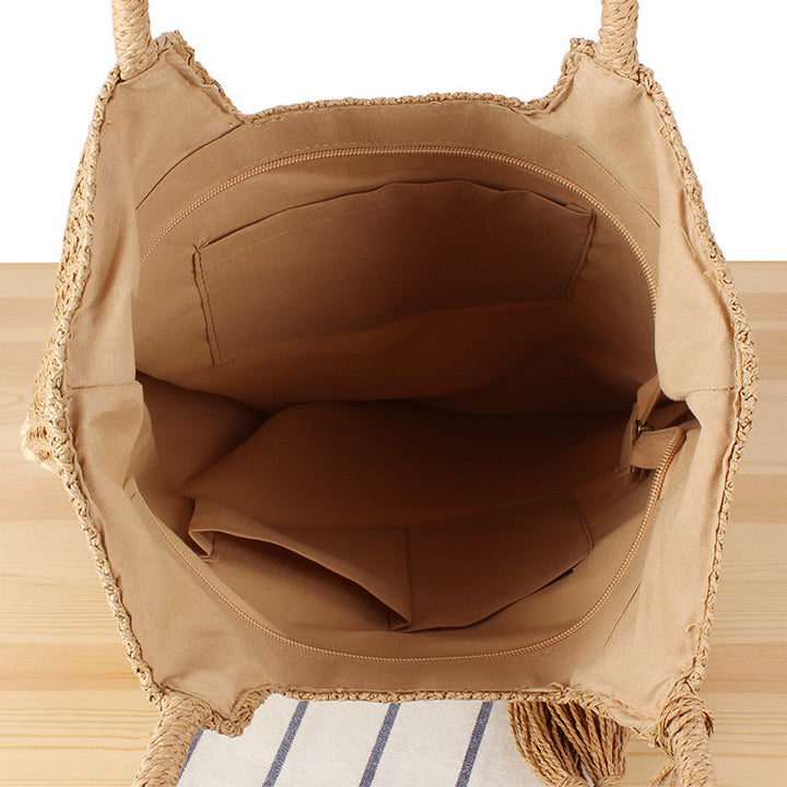 Fashionable beach tote bag made of woven natural material with fringed detail Bowlift