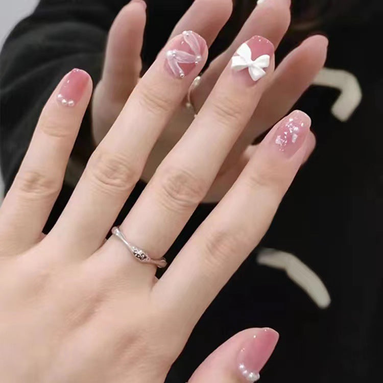 Glamorous nail art with pearl and bow accents Bowlift