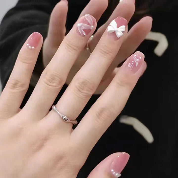 Glamorous nail art with pearl and bow accents Bowlift