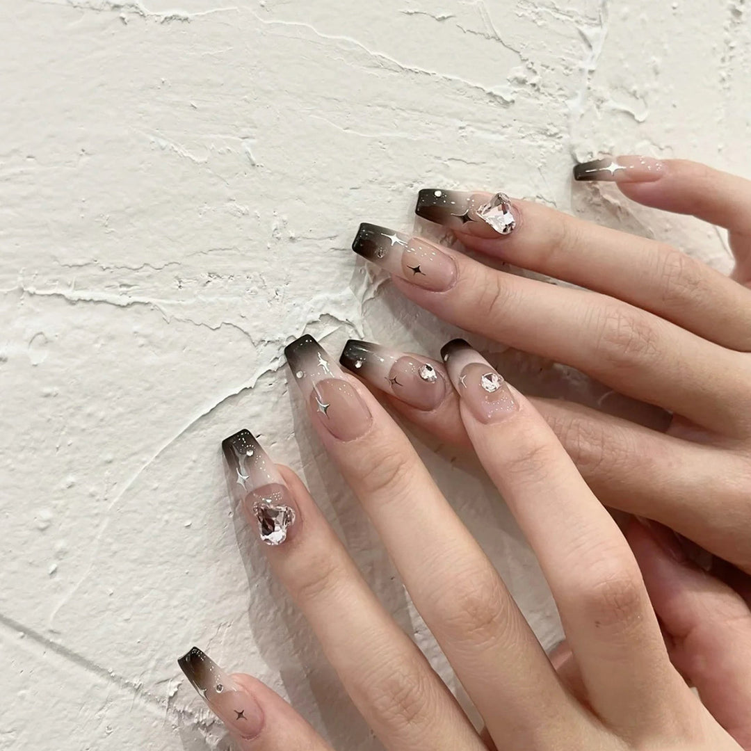 Artificial nail extensions with elegant ombre design and glitter accents Bowlift