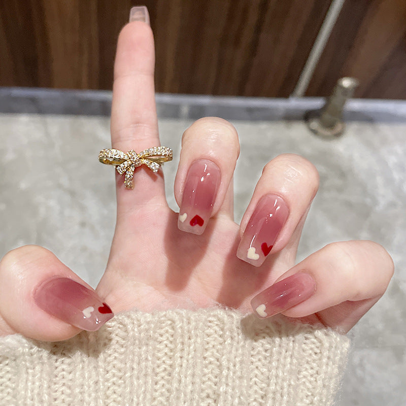 Glamorous artificial nails with heart design and glittering accents Bowlift