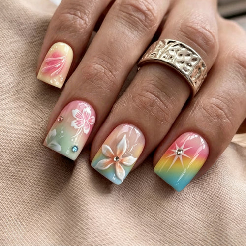 Artificial nails in vibrant floral design with glitter accents Bowlift