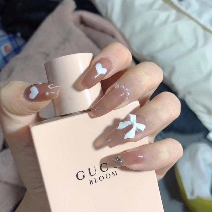 Glamorous artificial nails with heart design and glittering accents Bowlift