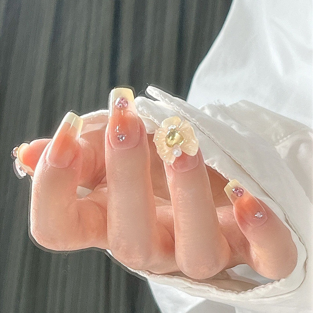 Artificial nail set with elegant floral decorations and glitter accents Bowlift