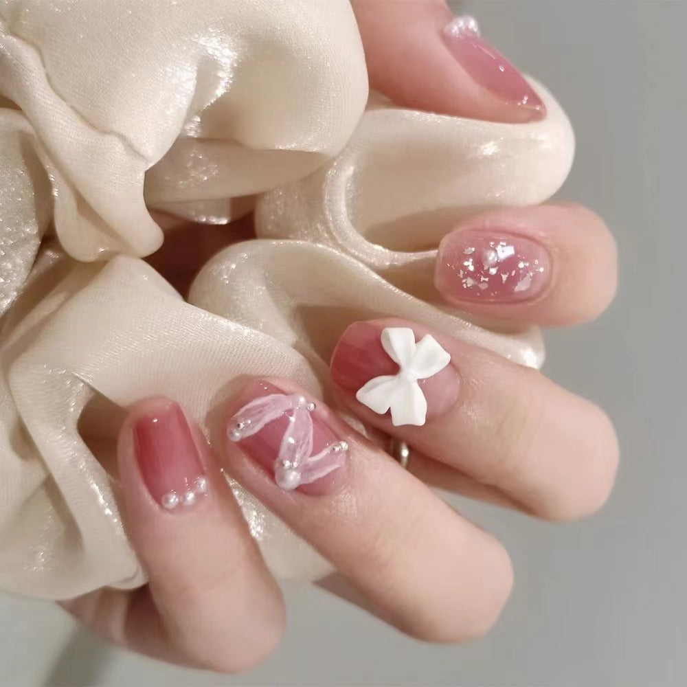 Glamorous nail art with pearl and bow accents Bowlift