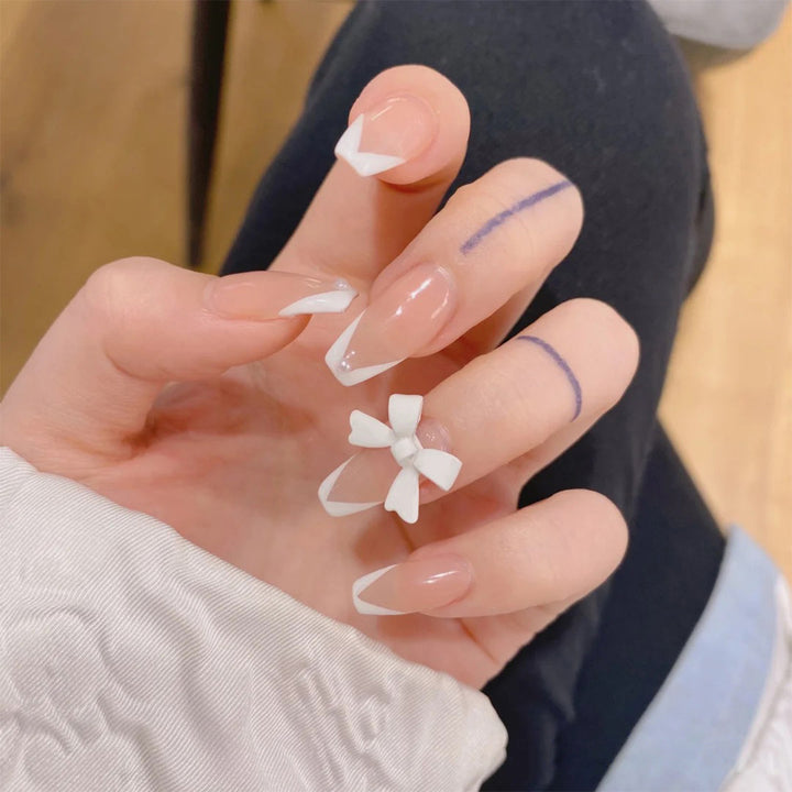 Elegant artificial nails with translucent French tip and decorative floral accents Bowlift
