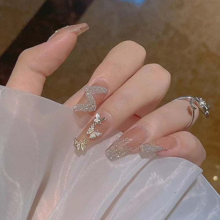 Glamorous artificial nails with heart design and glittering accents Bowlift