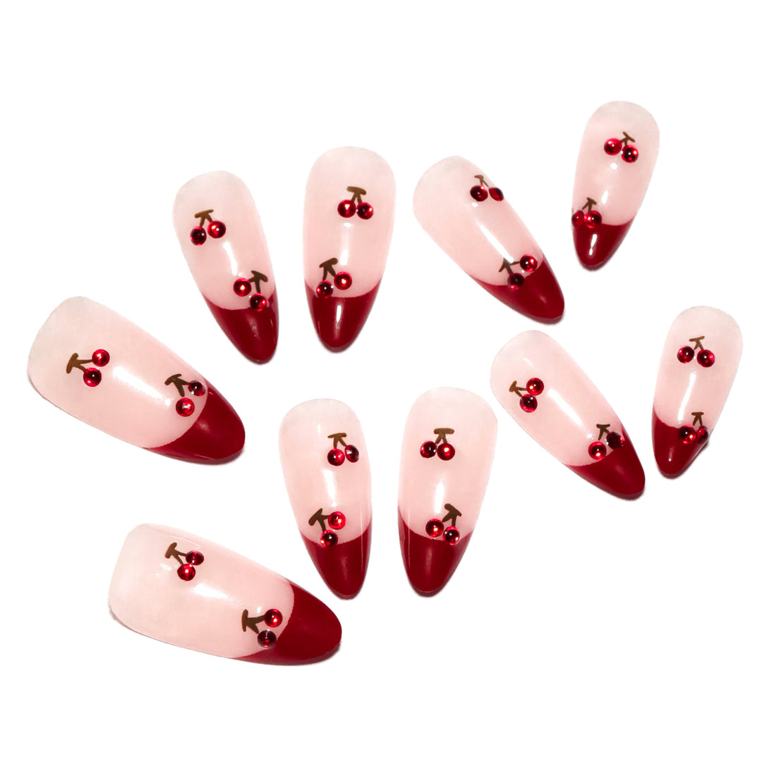 Artful stiletto nails with cherry motifs and glitter accents Bowlift