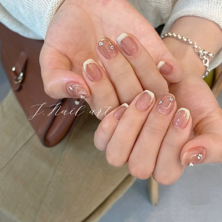 Acrylic nail set with elegant French tips and glitter accents Bowlift