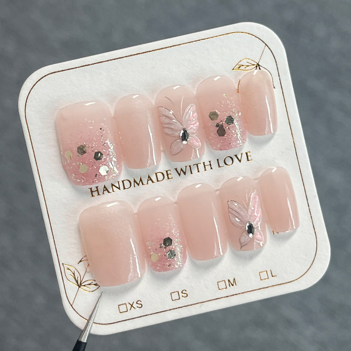 Artful nail art with butterfly designs and glitter accents Bowlift