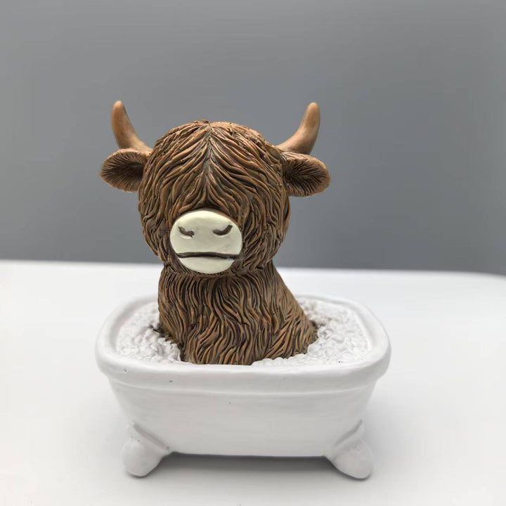Funny decorative figure of a Highland cow in a bathtub Bowlift
