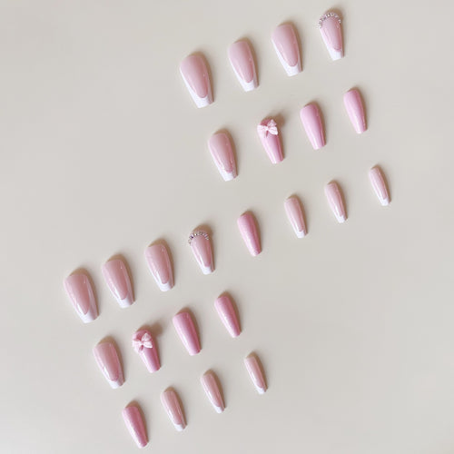 Artificial nail set with playful bows and glitter accents Bowlift