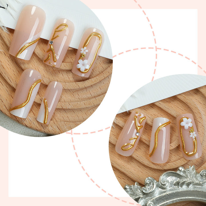 Elegant artificial nail set with golden accents and floral details Bowlift