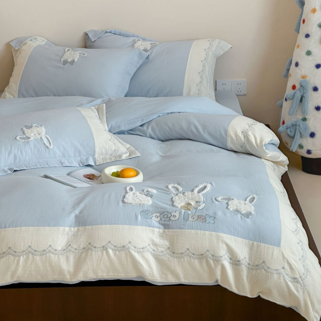 Embroidered cotton satin bedding set with appliquéd rabbit designs and decorative border