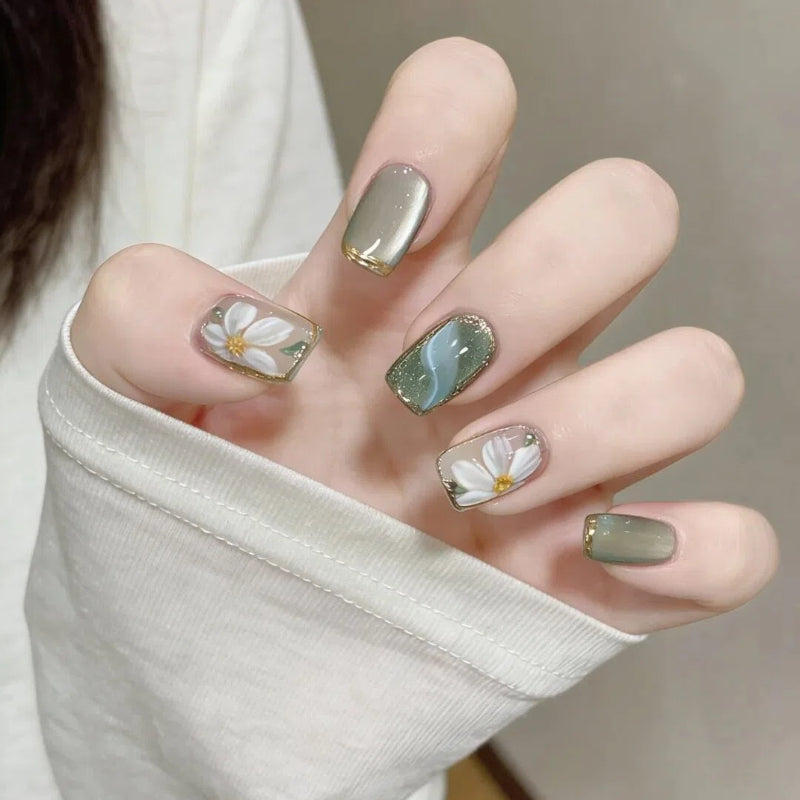 Artificial nails with floral accents and glamorous gold trim Bowlift