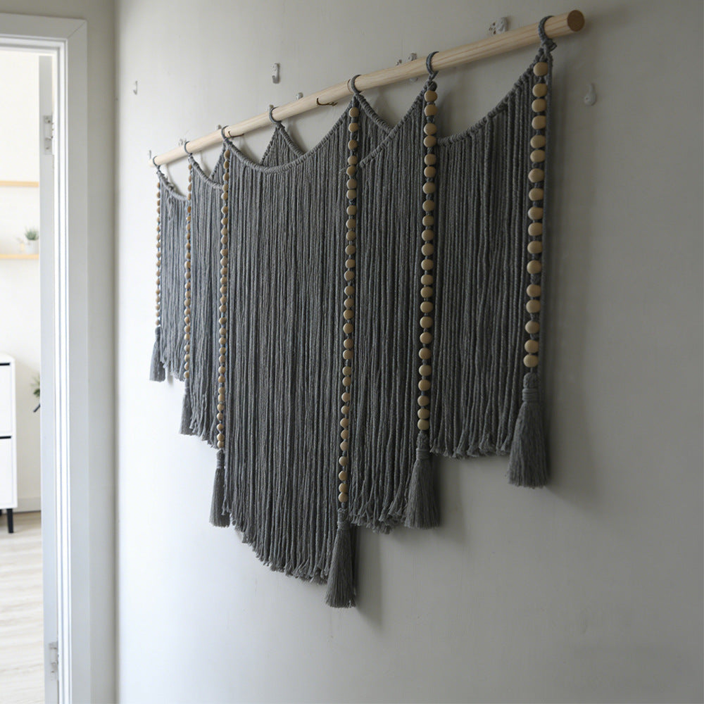 Macramé wall hanging with intricate fringes and wooden beads