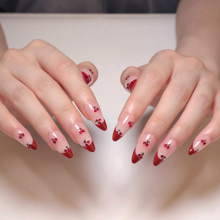 Artful stiletto nails with cherry motifs and glitter accents Bowlift