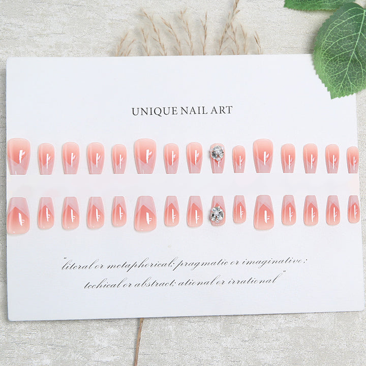 Artificial nail set with filigree tip designs and glamorous rhinestone accents Bowlift