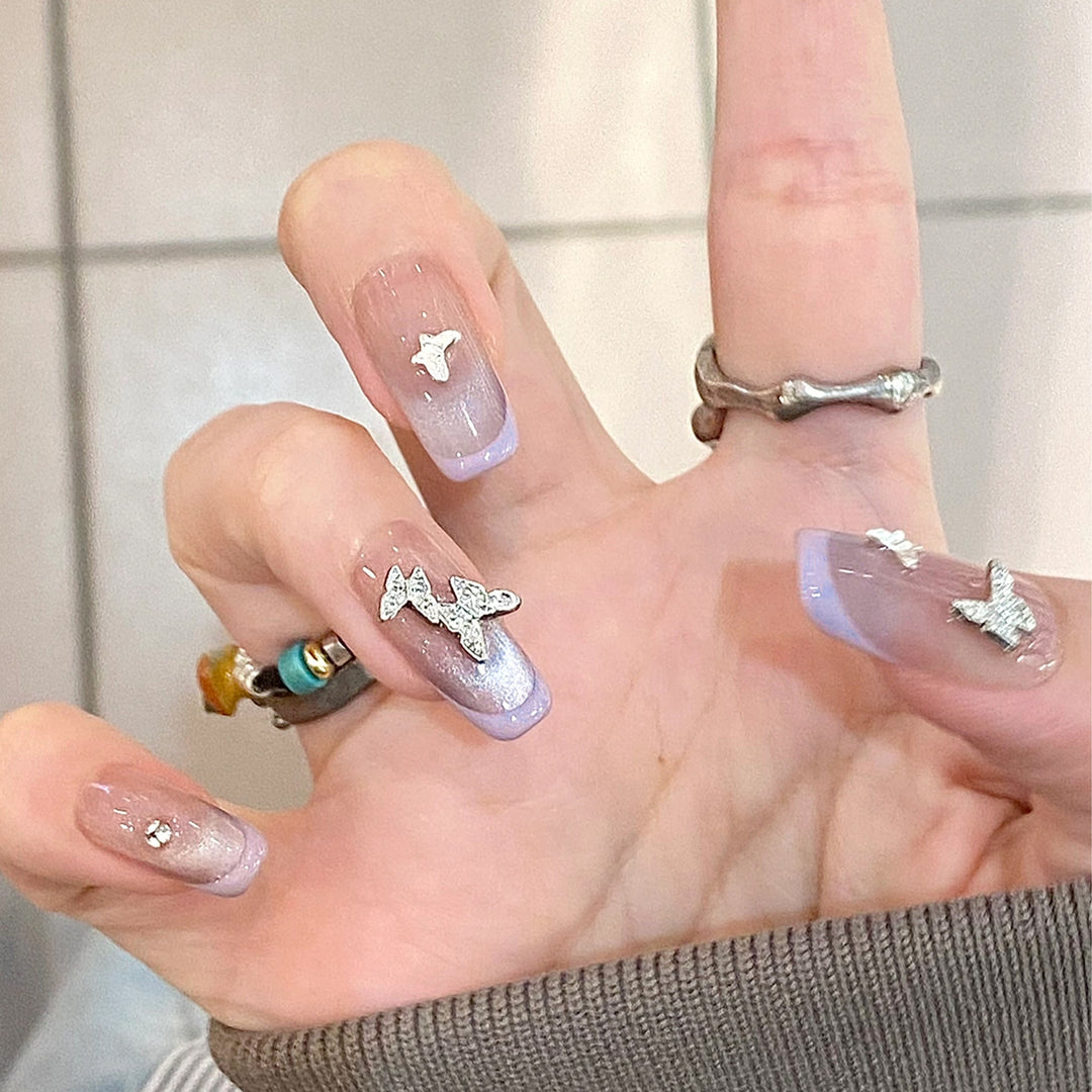 Artificial nail extensions with glitter design and elegant accents Bowlift