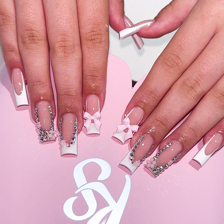 Artificial nail set with careful ribbon and glitter decorations Bowlift