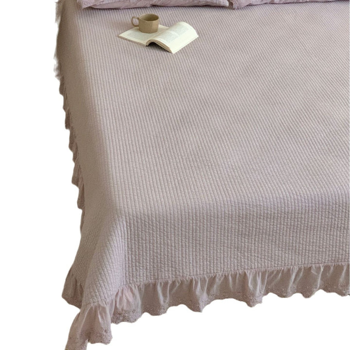 Quilted bedspread with ruffled trim and fine quilted texture