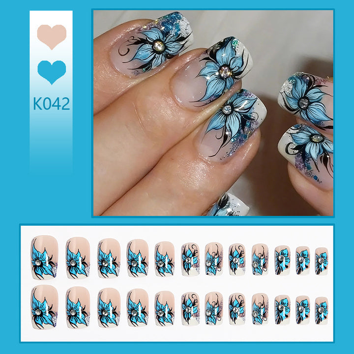 Artificial nail set with intricate floral designs and glitter elements Bowlift