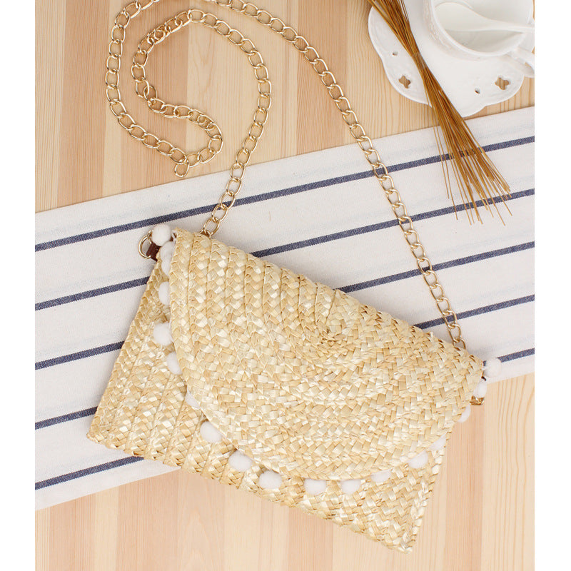 Clutch made of handwoven natural material with decorative pompons Bowlift