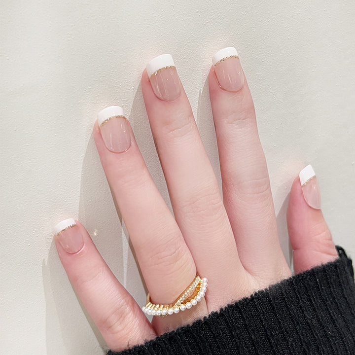 Artful nail extensions with elegant French tip and gold accents Bowlift