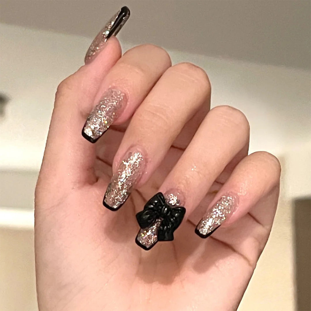 Artistic Nail Extensions with Glitter and Bow Accents Bowlift