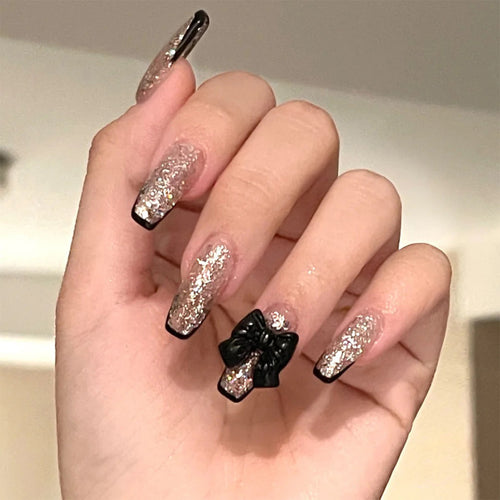Artistic Nail Extensions with Glitter and Bow Accents Bowlift